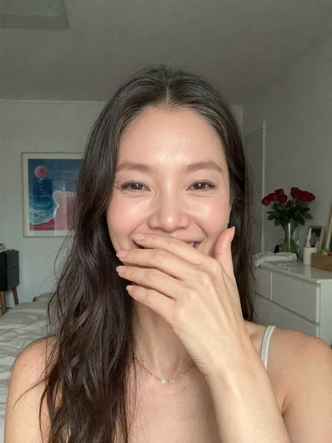 Nina smiling with her hand over her mouth